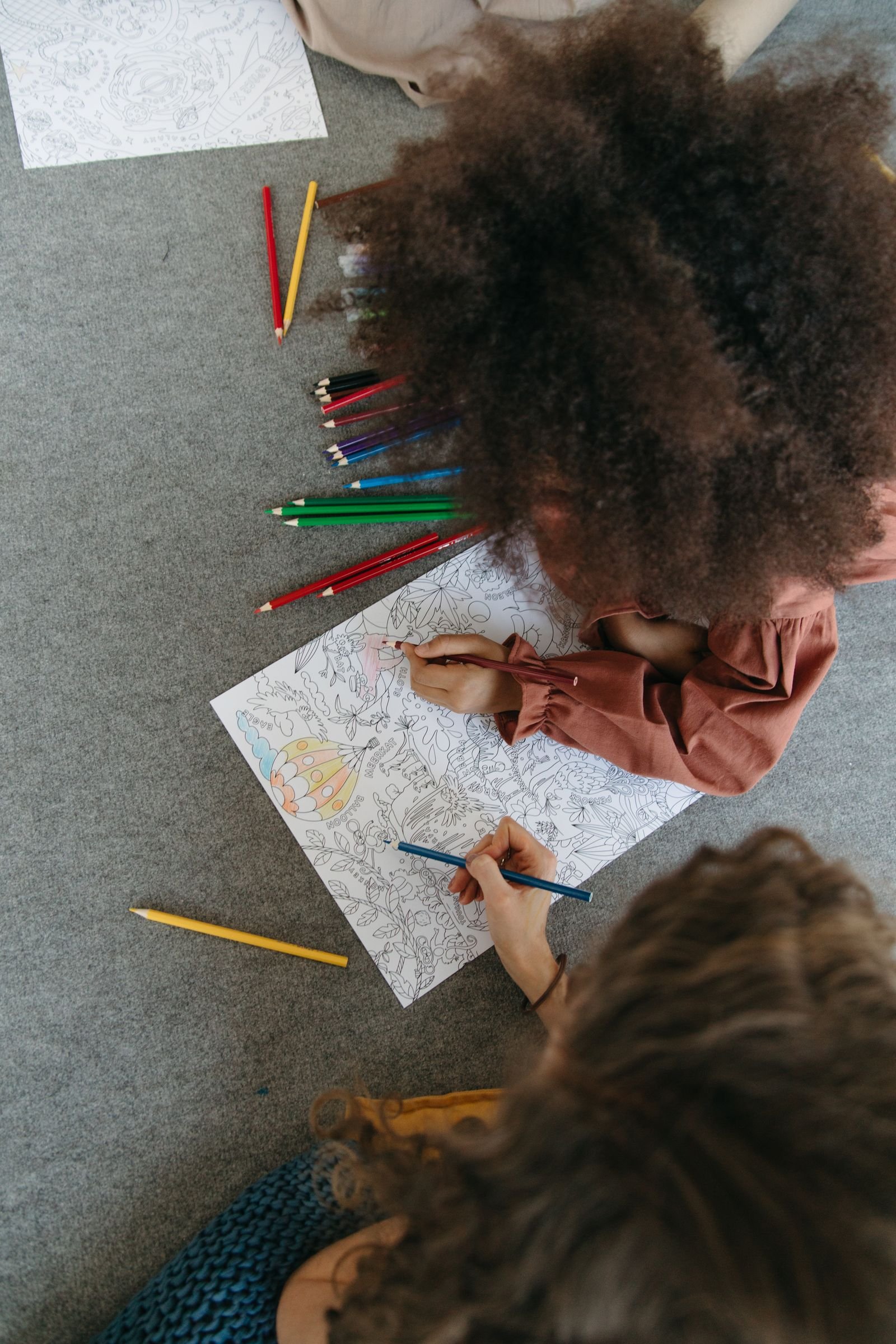 Two children drawing together with colorful pencils