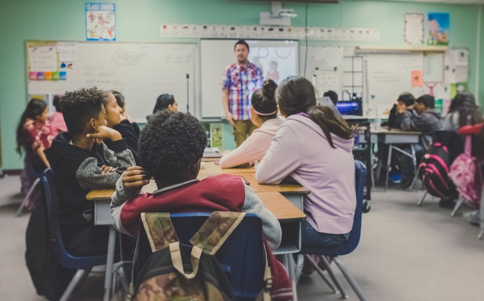Students listening to a teacher in a busy classroom